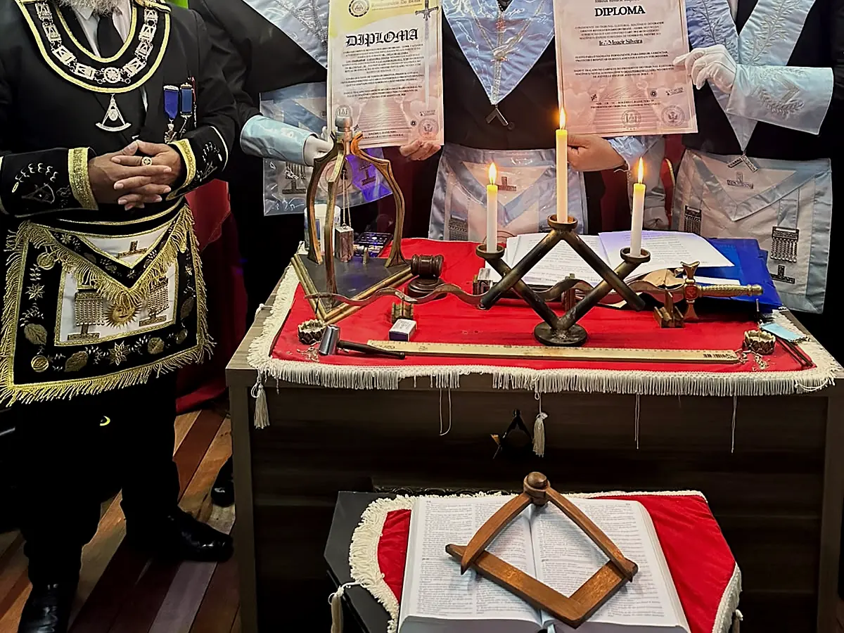 O Livro da Lei Sagrada com o esquadro, sobre o altar da Loja